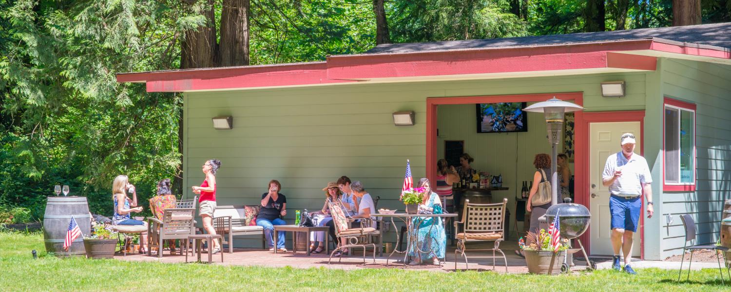 Cedar River Cellars Patio with people enjoying wine and conversation on a sunny day.